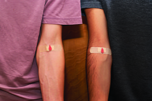 Two arms side by side with bandaids and a red blood drop