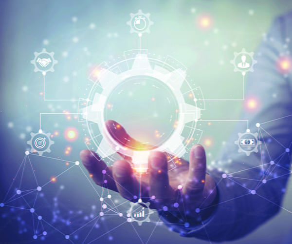 A business process management and workflow automation diagram with gears and icons floats above a person's upturned hand.