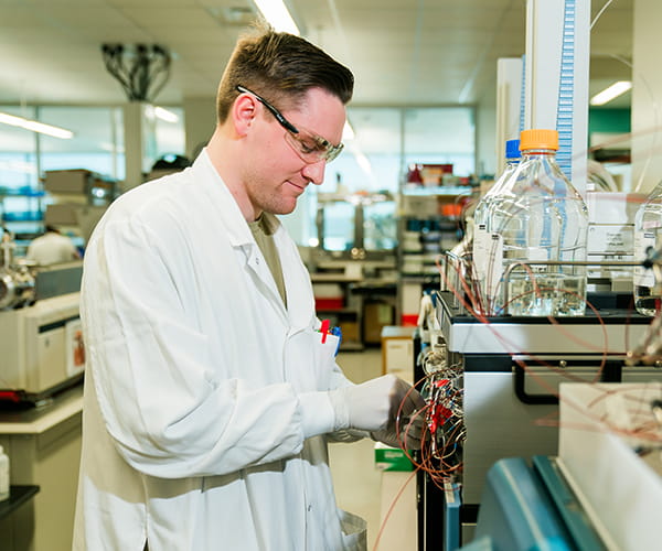 A male laboratory medicine professional works with a mass spectrometry instrument. Image credit: Kurstin Roe