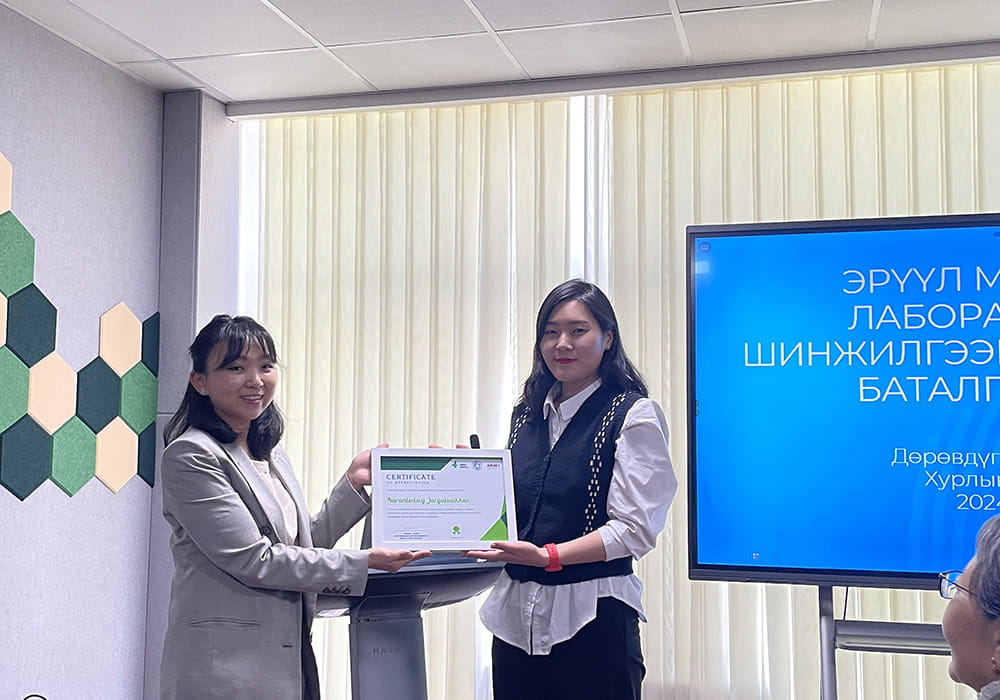 A woman being presented with a certificate by another woman