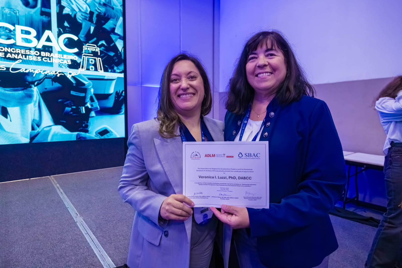 Jessica Colon-Franco awarding Veronica Luzzi with a certificate after presenting in the ADLM/SBAC workshop in São Paulo, Brazil