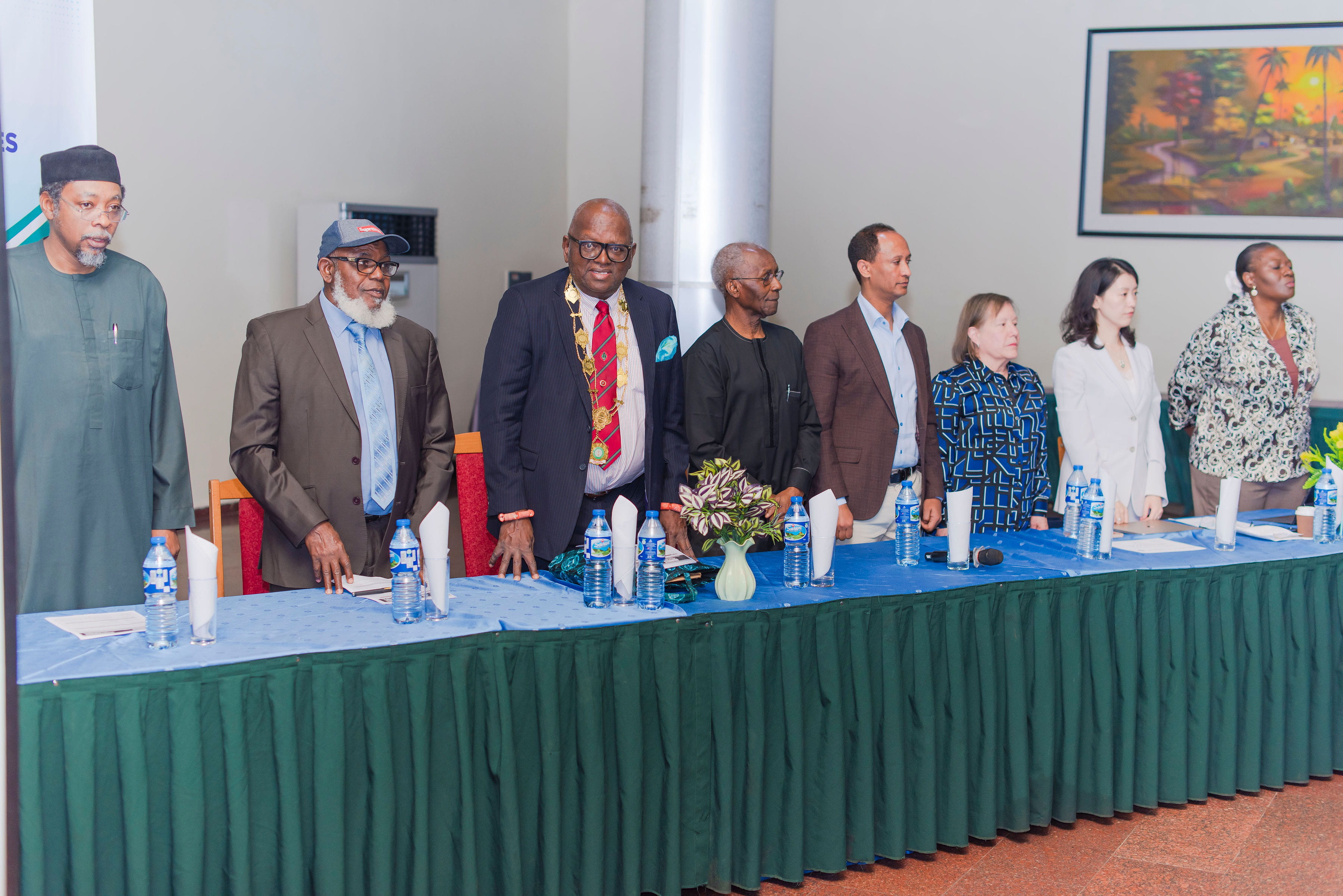 Members of ADLM's Global Affairs' Subcommittees standing at a table with leadership from the Association of Clinical Chemists Nigeria.