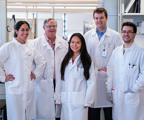 A diverse group of laboratory medicine professionals standing together.