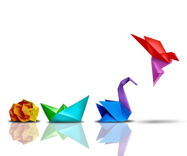 A piece of paper morphs into an origami swan that then takes flight.