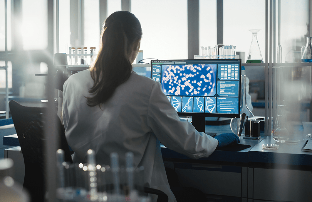 A woman in a laboratory looks at a desktop.