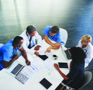 Birds eye view of doctors at a table looking over papers