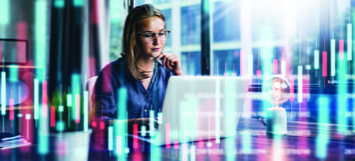 A image with a digitized background and a female sitting at a table looking at her laptop 