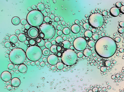 A microscopic view of saliva with a blue background