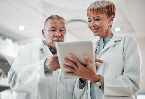 Clinical laboratory scientists discuss a blood test report using laboratory information system software