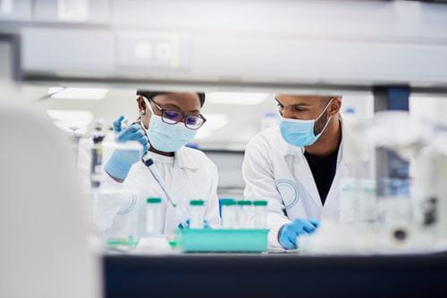 Two medical laboratory scientists collaborate on cutting-edge syndromic PCR testing for respiratory infections