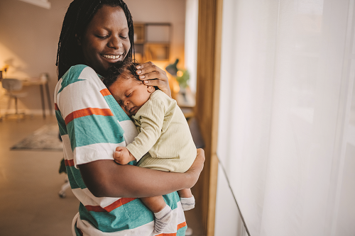 Mother holds her baby smiling with improved diagnostics and clinical care