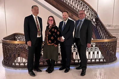 Speakers posed in front of stairs during congressional briefing