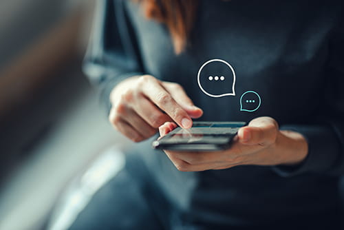 A woman scrolling on her phone as typing bubbles appear